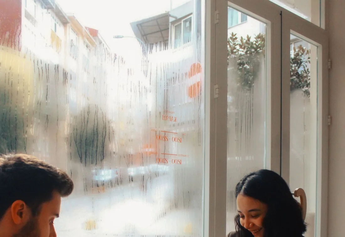 Zwei Personen im Gespräch am Fenster, Nahaufnahme